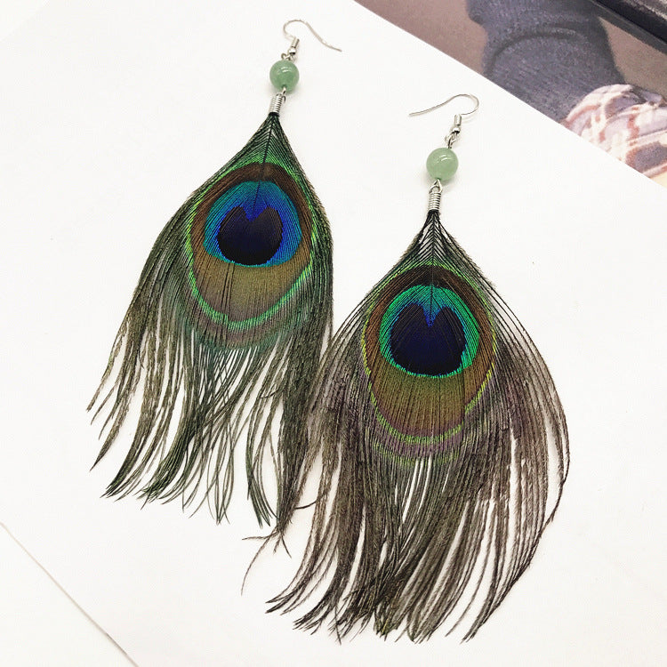 Close-up of stylish tassel earrings showcasing peacock feathers